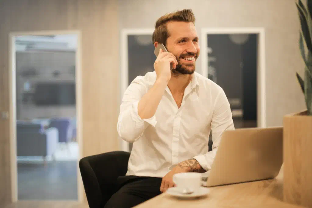 Vyras kalba telefonu ir šypsosi